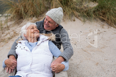 Senior couple sitting together on beach