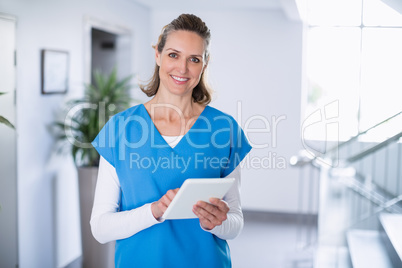 Portrait of smiling doctor using digital tablet