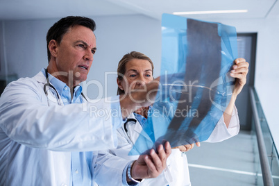 Male and female doctor discussing over x-ray report