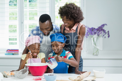 Parents and kids preparing food in kitchen