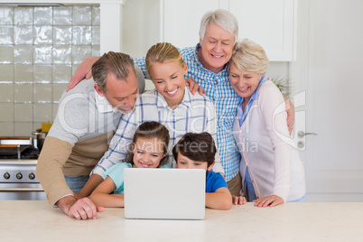 Family using laptop in kitchen