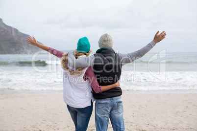 Mature couple standing with arms outstretched