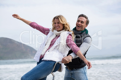 Mature couple riding bicycle on the beach