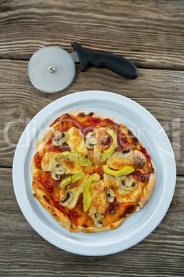 Italian pizza served in a plate with pizza cutter