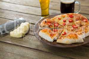 Italian pizza served on a pizza tray with a beer mug and glass