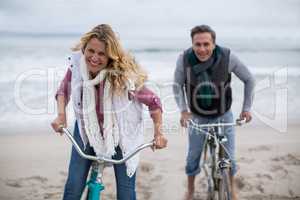 Mature couple riding bicycles on the beach