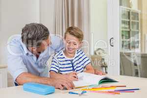 Father assisting son doing homework