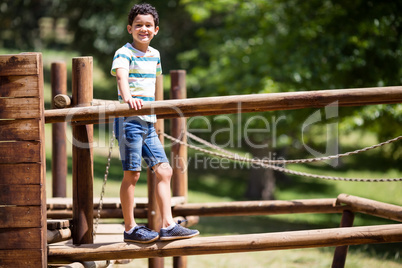 Boy standing on a playground ride in park