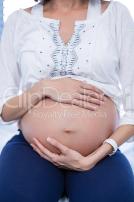 Mid section pregnant woman relaxing in ward