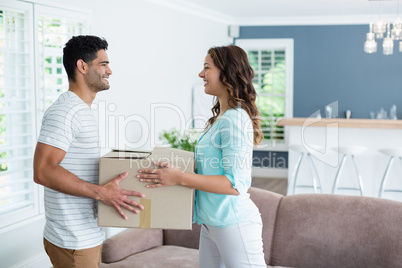Couple holding card boxes in living room