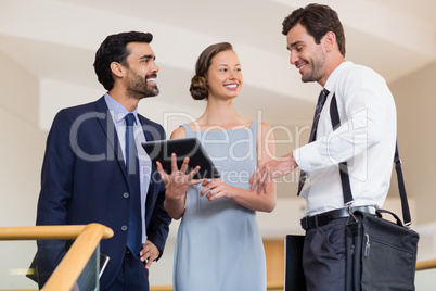 Business executives discussing over digital tablet