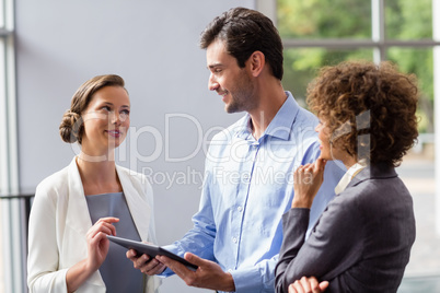 Business executives discussing over digital tablet