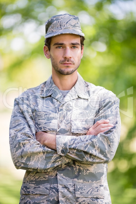 Soldier standing with arms crossed in park