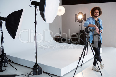 Happy male photographer standing in studio