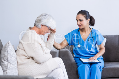 Doctor consoling senior patient