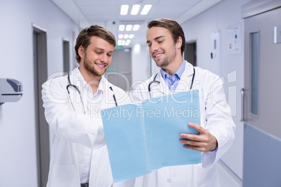 Doctors having discussion on file in corridor