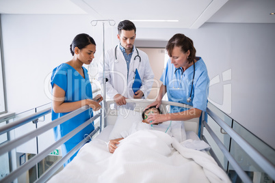 Doctors examining patient in corridor