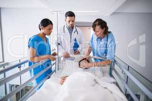 Doctors examining patient in corridor