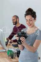 Female photographer reviewing captured photos in her digital camera