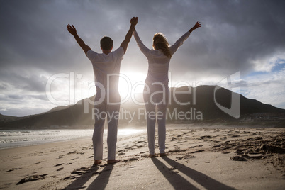 Couple standing with holding hands on the beach