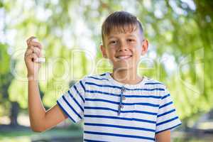 Boy holding asthma inhaler in park