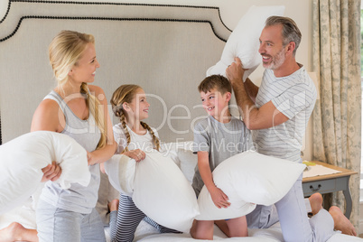 Cute family having a pillow fight in bedroom