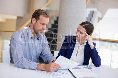 Businesswoman working at desk with colleague