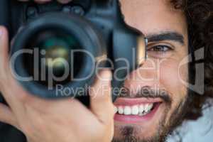 Happy male photographer with digital camera in studio