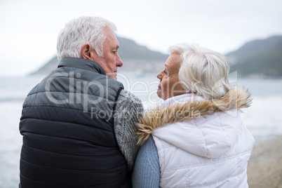 Senior couple sitting on rock at beach