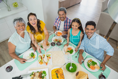 Happy multi generation family having meal on table at home Happy multi generation family having meal on table at home