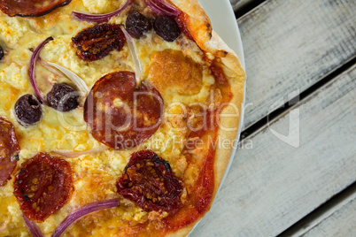 Italian pizza in a plate on a wooden plank