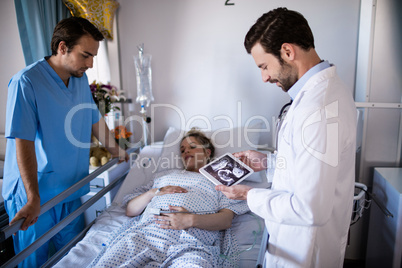 Male doctor looking at sonography report on a digital tablet