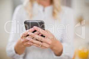 Woman using mobile phone at home