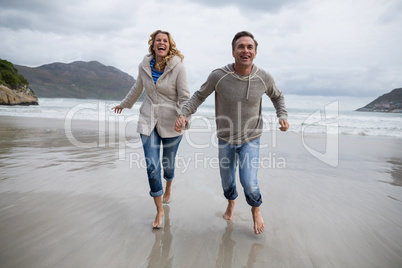 Mature couple running on the beach