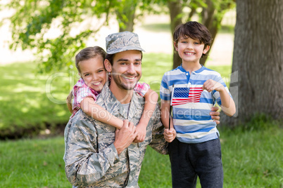 Happy soldier with his son and daughter in park