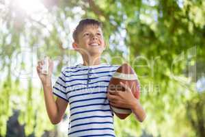 Smiling boy holding asthma inhaler and a rugby ball