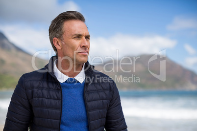 Man standing on the beach looking at ocean