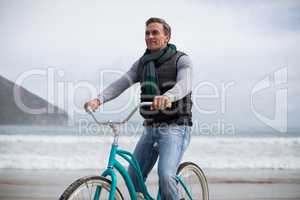 Mature man riding bicycle on the beach