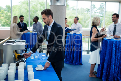 Business executive taking coffee from coffee maker