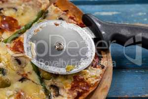 Delicious pizza served on pizza tray with cutter