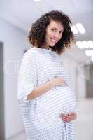 Portrait of pregnant woman standing in corridor