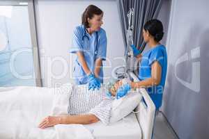 Doctor and nurse treating senior patient in ward