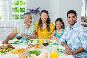 Happy multi generation family having meal on table at home