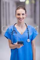 Portrait of female doctor using mobile phone in corridor