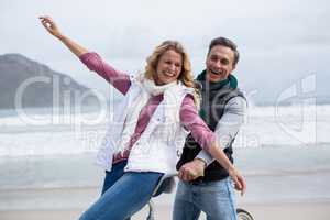 Mature couple riding bicycle on the beach