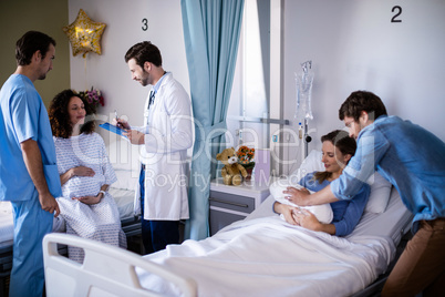 Couple with their newborn baby in the ward