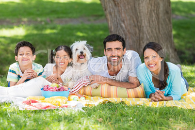 Portrait of family enjoying together with their pet dog in park