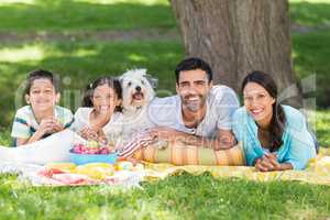 Portrait of family enjoying together with their pet dog in park