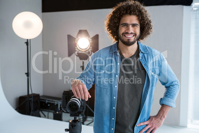 Happy male photographer standing in studio