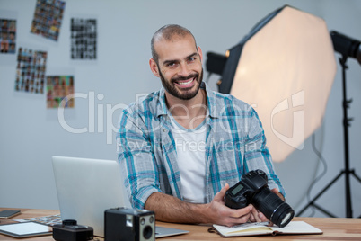 Male photographer reviewing captured photos in his digital camera